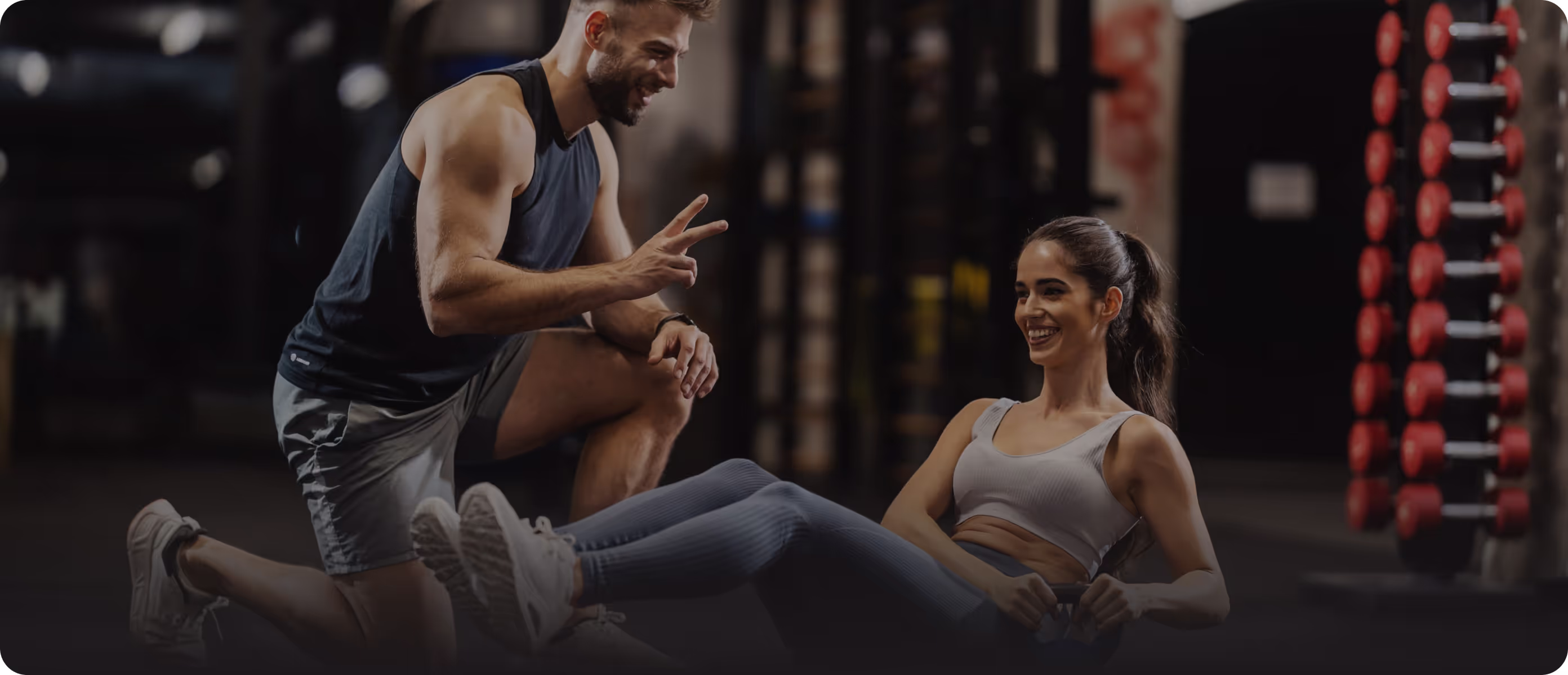 Personal trainer counts crunches for a client in the gym