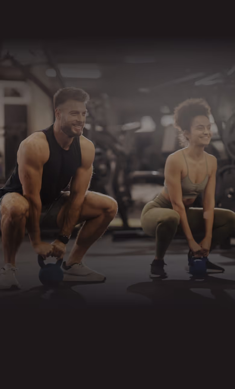2 people working out in the gym using dumbbells